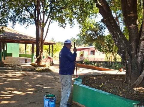 Voluntário pintando o muro do terreno