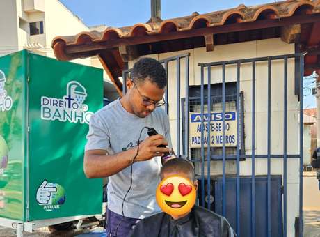 Voluntário cortando o cabelo de um atendido